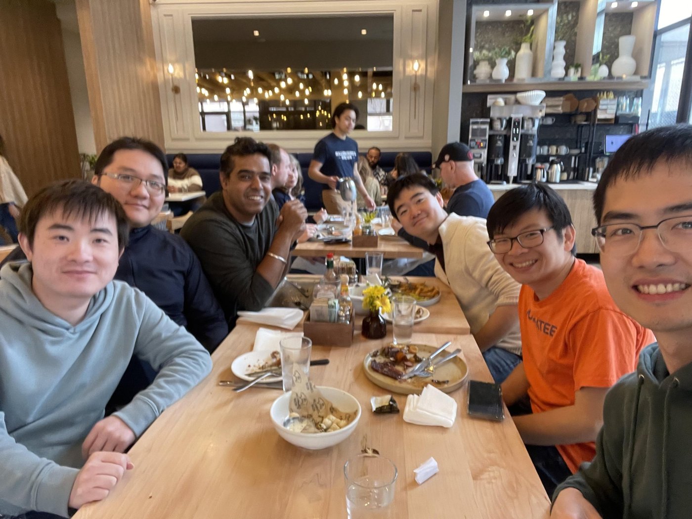 Colleagues along a long café table; Michael at right foreground