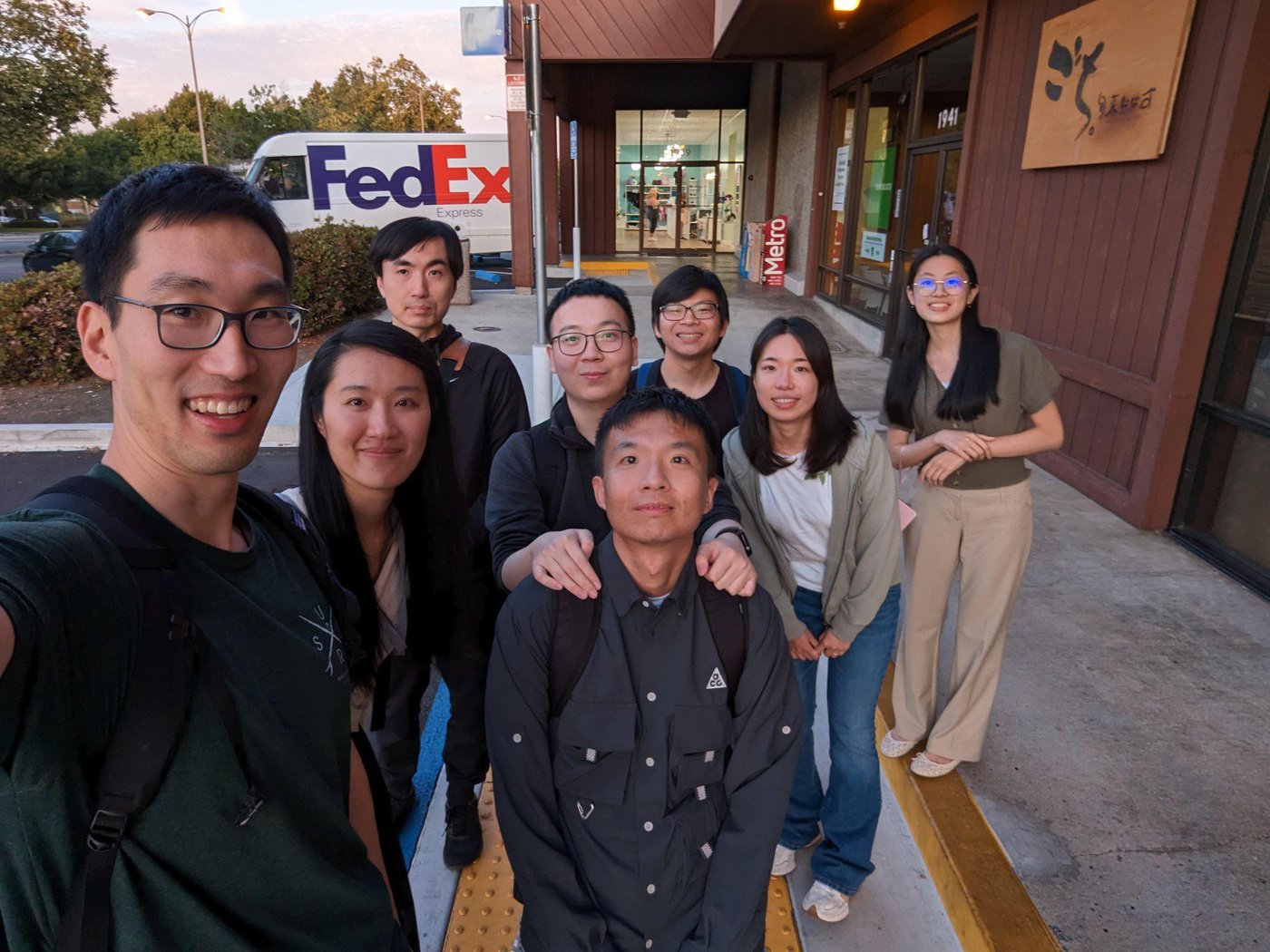 Seven colleagues on a sidewalk at dusk